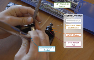 Hands using a tool with an assembly order diagram on a wooden surface